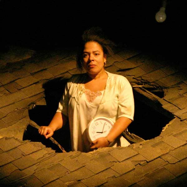 an actor poking out thru a hole in a roof