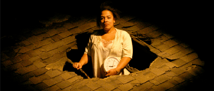 an actor pokes thru a hole in a roof