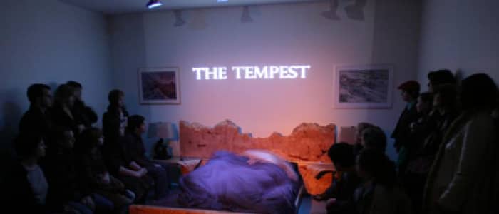 "The Tempest" projected on a wall surounded by audience members